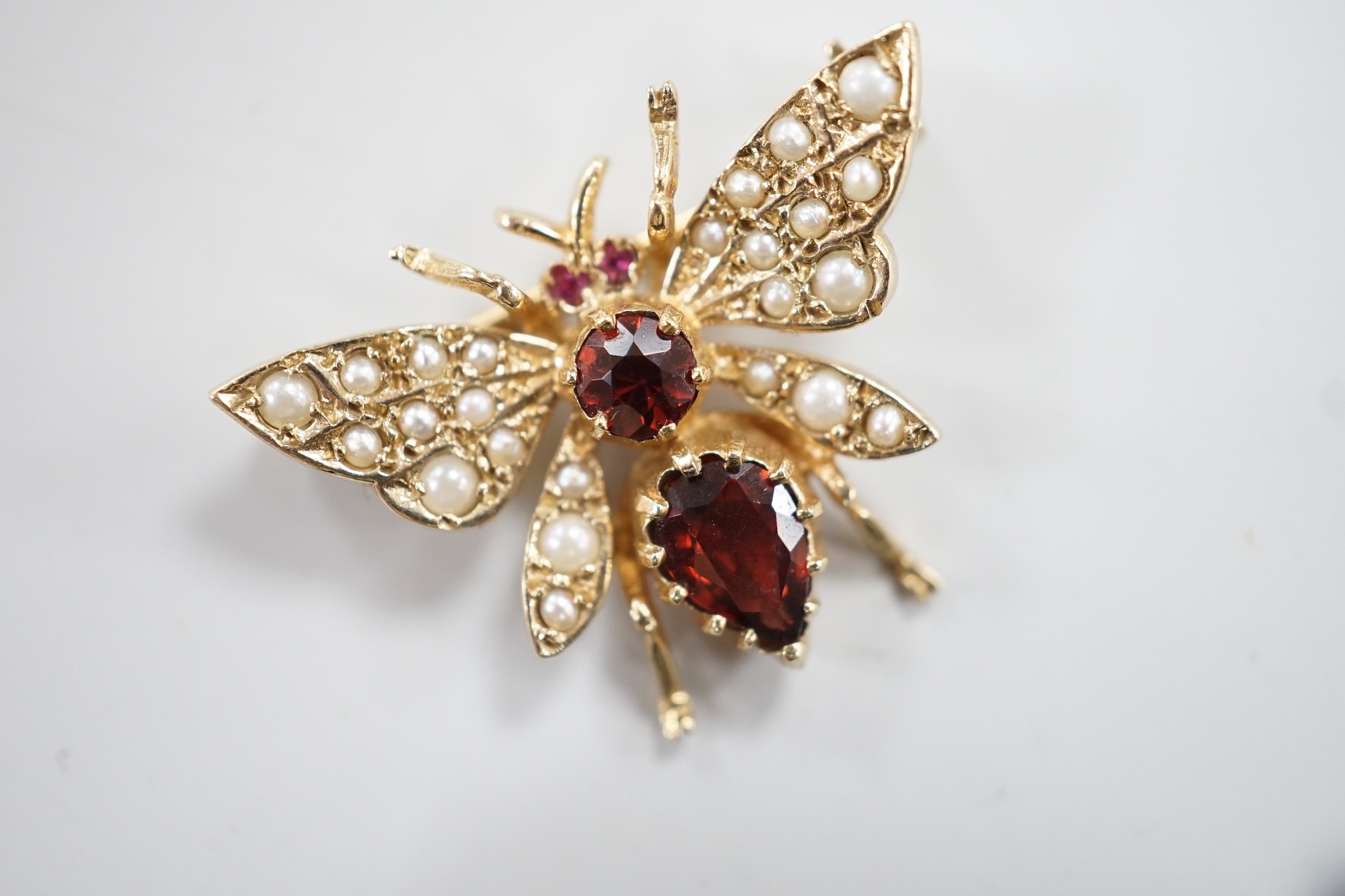 A modern 9ct gold, garnet and split pearl set bug brooch, width 26mm, gross weight 3.8 grams.